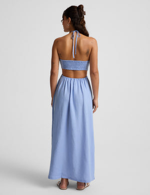 Woman wearing a light blue dress on a gray background. 