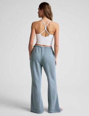Rear view of light blue Fade Out Mid-Rise Sweatpant featuring a gathered elastic waistband and full-length flared legs.