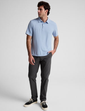 Man wearing a light blue polo shirt against a plain background. 