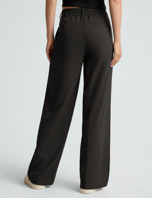 Rear view of black Status Wide Leg Trouser featuring an elastic waistband, belt loops, welt pocket, and loose straight leg.