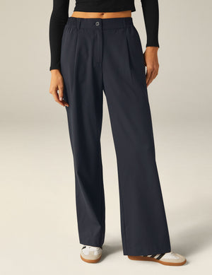 Status Wide Leg Trousers in dark navy with a pleated front, elasticated waistband, and a relaxed straight-leg silhouette.