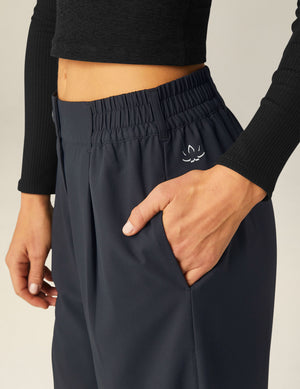Black Status Wide Leg Trousers featuring an elastic waistband, belt loops, and side pocket with a small white brand logo.