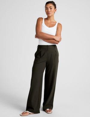 Status Wide Leg Trouser in olive on a model, featuring front pleats, a mid-rise waist, and a relaxed, straight-leg silhouette.