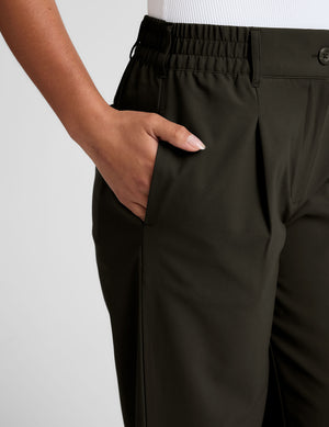 Close-up of olive Status Wide Leg Trouser featuring a hand in the side pocket, front pleats, and an elasticated waistband.