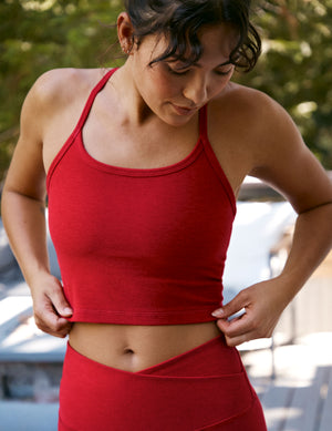 woman wearing a red slim racerback cropped tank and leggings outdoors. 